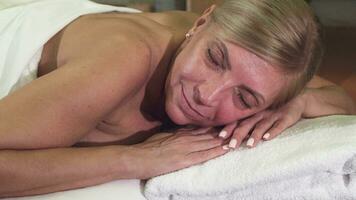 Relaxed woman lies on a massage table video