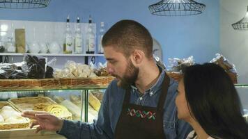 Professional male baker working at his shop helping his mature female customer video