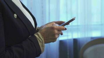 Business woman is typing a message on her mobile phone video