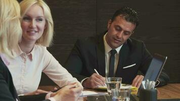 The man signs some papers, looks at the camera and smiles video