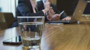 Closeup of a glass of water and an iPhone that lie on a table video