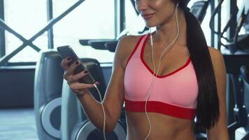 a fofa menina tipos alguma coisa dentro a telefone entre Esportes exercícios video