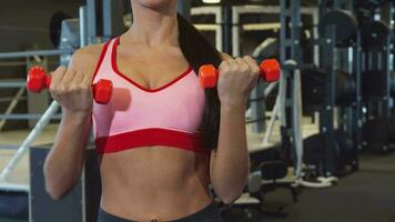 The sports girl does special exercises for hands with two dumbbells video