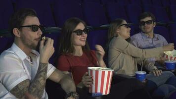 dos parejas sentar en el cine y comer palomitas de maiz video