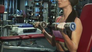 A strong girl zealously pumps the muscles of her hands video