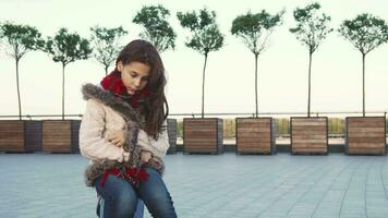 A sweet girl sits in the middle of the street and being sad video