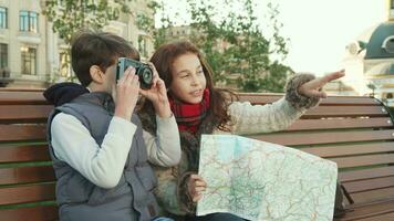 Young guys sit on a bench and take pictures of sights video