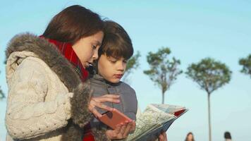 actif les enfants essayer à trouver le suivant endroit de leur route avec une carte et mobile téléphone video