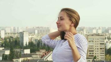 uma jovem menina goza a clima enquanto em pé em a cobertura video