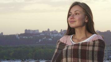 Lovely girl hiding behind a rug and enjoying the view from the roof video