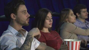Two young couples watching the premiere of a new film video