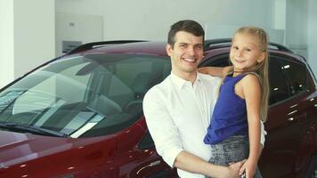 papà e figlia su il suo mani In piedi su il sfondo di il auto video