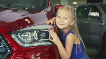 mooi weinig is meisje poseren Aan auto achtergrond video