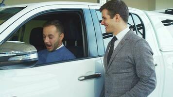 A handsome buyer makes a selfie with a seller from the car video