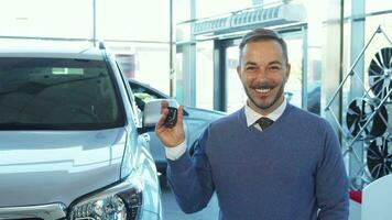 un increíblemente contento comprador sostiene el llaves a un nuevo coche video