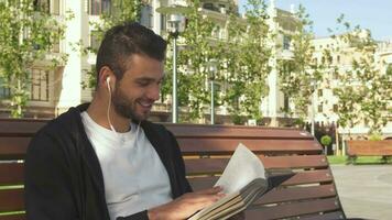 uma feliz cara é lendo uma livro dentro uma cidade beco video