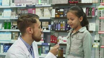 une amical pharmacien secoue mains avec une peu fille video