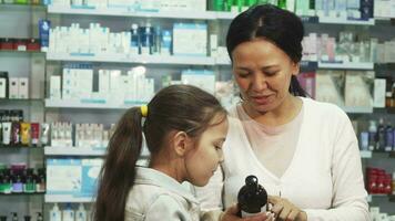 un' sorridente donna sceglie con sua figlia qualcosa nel il farmacia video