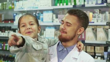 un simpático farmacéutico es participación un pequeño niña en su brazos video