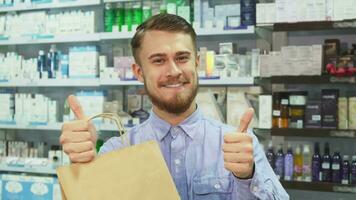 el hombre hecho un compra en un farmacia y demostración pulgares arriba video