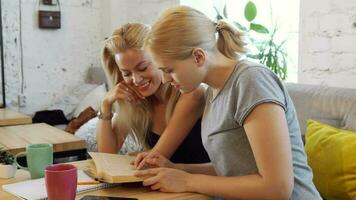 Two girls are reading a book video