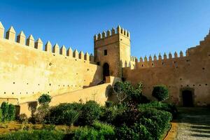 the castle walls are made of stone and have many turrets photo