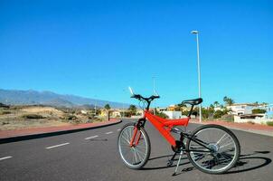 a red bike is parked in the road photo