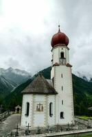 a small white church in the mountains photo