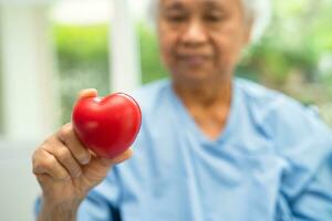 Doctor holding a red heart in hospital, healthy strong medical concept. photo