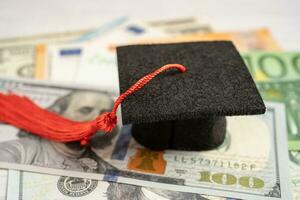 Sombrero de brecha de graduación en billetes de euro y dólar estadounidense, concepto de enseñanza de aprendizaje de tarifa de estudio de educación. foto