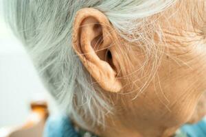 Ear of Asian senior woman, listening or hearing loss problem. photo