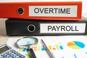 Overtime, Payroll. Binder data finance report business with graph analysis in office. photo