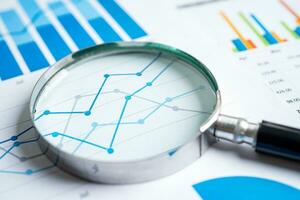 Magnifying glass on graph paper. Financial development, Banking Account, Statistics, Investment Analytic research data economy, Business concept. photo