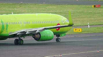 DUSSELDORF, GERMANY JULY 23, 2017 Boeing 737, VP BND of S7 Airlines taxiing at Dusseldorf airport, side view. Footage of passenger plane on the runway video