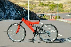 a red bicycle is parked on the side of the road photo