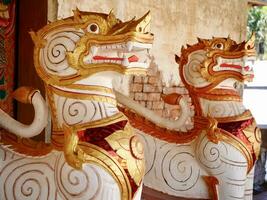 The lion statue decorated at the base of Sinhalese style pagoda that contain Buddha relics located at the War Sri Pho Chai old temple of the Sangha is over 400 years old photo