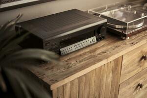 Amplifier and vinyl record player on a wooden sideboard photo