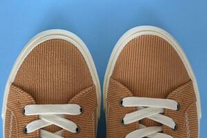 Beige corduroy sneakers on a blue background photo