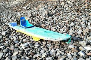 a surfboard sits on the rocks photo