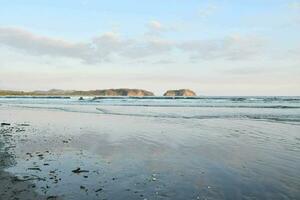 a beach with mountains in the distance photo