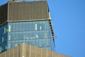 Glass building with transparent facade of the building and blue sky. Structural glass wall reflecting blue sky. Abstract modern architecture fragment. Contemporary architectural background. photo