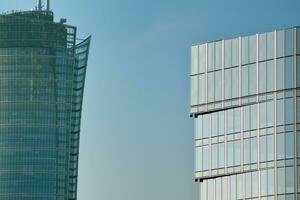 Glass building with transparent facade of the building and blue sky. Structural glass wall reflecting blue sky. Abstract modern architecture fragment. Contemporary architectural background. photo