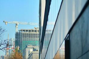 Glass building with transparent facade of the building and blue sky. Structural glass wall reflecting blue sky. Abstract modern architecture fragment. Contemporary architectural background. photo