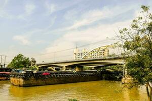 a river with a bridge and a boat in the water photo