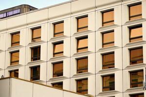 moderno oficina edificio en el ciudad con ventanas y acero y aluminio paneles pared. contemporáneo comercial arquitectura, vertical convergente geométrico líneas. foto