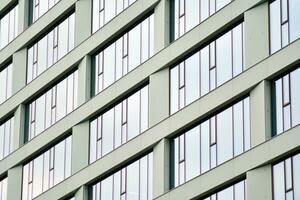 Glass building with transparent facade of the building and blue sky. Structural glass wall reflecting blue sky. Abstract modern architecture fragment. Contemporary architectural background. photo