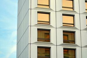 moderno oficina edificio en el ciudad con ventanas y acero y aluminio paneles pared. contemporáneo comercial arquitectura, vertical convergente geométrico líneas. foto