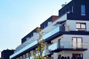 New apartment building with glass balconies. Modern architecture houses by the sea. Large glazing on the facade of the building. photo