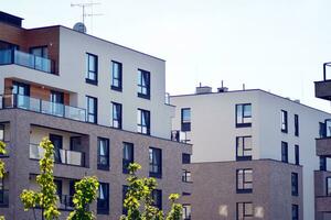 New apartment building with glass balconies. Modern architecture houses by the sea. Large glazing on the facade of the building. photo