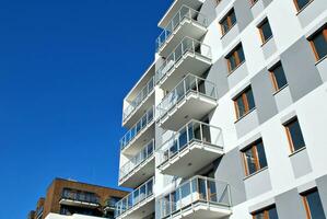 New apartment building with glass balconies. Modern architecture houses by the sea. Large glazing on the facade of the building. photo